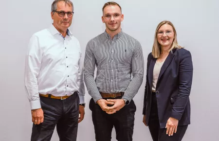 Werksleiter Thomas Wiesmann und Ausbildungsleiterin Franziska Niedergriese beglückwünschen Emilijan Davcik zu seiner herausragenden Leistung.